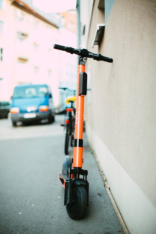 Orange electric scooter on sidewalk - best for adults